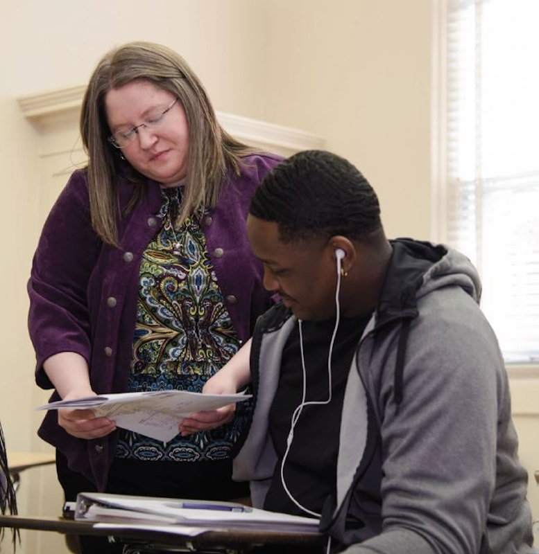 Leslie-Gomes-works-with-student-e1554310137945