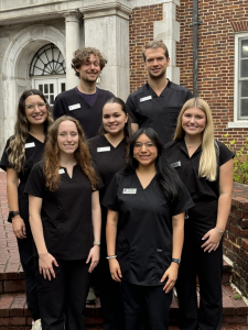 The seven 2024 2025 DNT Grad Students standing on the steps of McAlister Hall